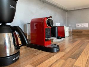 若西耶Magnifique appartement 8 couchages dans villa historique的红色咖啡机,位于木地板上