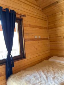 泰斯Thethi Paradise Hotel & Restaurant的小木屋内的卧室,设有窗户