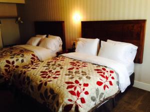 Neguac博塞茹尔汽车旅馆的酒店客房带两张带白色和红色床单的床。