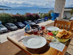 博德鲁姆Kumbahçe Fethiye Hanım Pansiyon BODRUM的一张桌子,上面放着盘子,享有海景