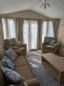 Lytchett MinsterSea Shore Chalet - Rockley Park的客厅配有两张沙发和一张桌子