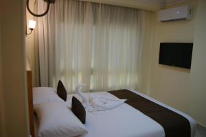 赫尔格达Palm Inn City Hotel的酒店客房,配有一张带天鹅的床
