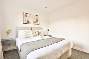 卡迪夫StayRight 3 Bed House with Private Parking的卧室配有一张带白色床单和枕头的大床。