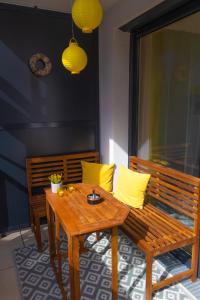 维也纳Danube City Lodge, uptown, A/C的天井上配有木桌和带黄色枕头的长凳