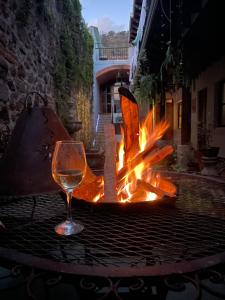 危地马拉安地瓜Autumn in Antigua Boutique Hotel的坐在火炉旁的桌子上喝一杯葡萄酒