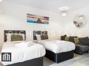 赫默尔亨普斯特德Cosy Studio Apartment- Hemel Hempstead High Street的带沙发的客房内的两张床