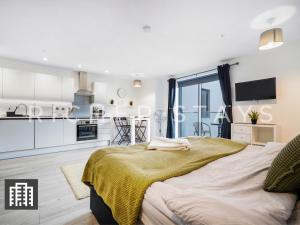 赫默尔亨普斯特德Cosy Studio Apartment- Hemel Hempstead High Street的一间带大床的卧室和一间厨房