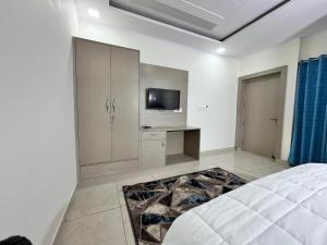 哈尔德瓦尼Cosy stay的一间卧室配有一张床和一台电视。