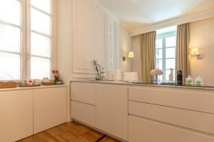 斯培西亚Cavallotti 22的厨房配有白色橱柜和窗户。