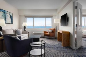 伊利Sheraton Erie Bayfront Hotel的客厅配有沙发、椅子和桌子