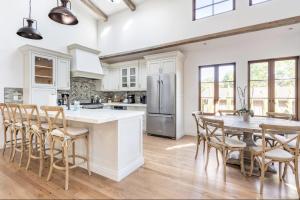 WoodsideExquisite luxury executive cottages的厨房配有桌椅和冰箱。