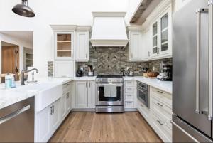 WoodsideExquisite luxury executive cottages的厨房配有白色橱柜和不锈钢冰箱