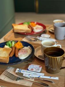 富山Hotel Torni ホテル トルニ的一张木桌,上面放着早餐食品和咖啡盘