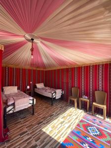 瓦迪拉姆Glamp Camp Wadi Rum的客房设有两张床和天花板。