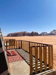 瓦迪拉姆Glamp Camp Wadi Rum的沙漠中间的木甲板