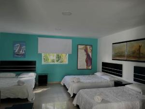 圣安德烈斯圣米格尔别墅酒店的带三张床和蓝色墙壁的客房