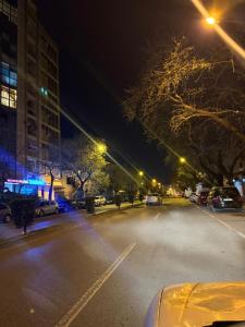 斯库台Temali Apartment的一条空荡荡的街道,晚上有汽车停在停车场