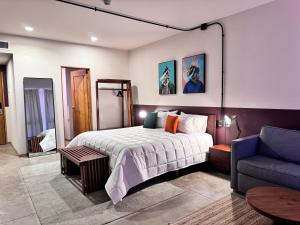 瓜达拉哈拉Hotel Olá Chapultepec的一间卧室配有一张床和一张蓝色的沙发