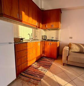 希马拉Fane's Apartments的厨房配有木制橱柜、水槽和冰箱。