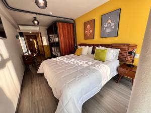 瓜达拉哈拉Hotel Olá Chapultepec的卧室设有一张白色大床和黄色的墙壁