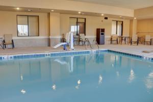 特克萨卡纳特克萨卡纳东智选假日酒店&套房的酒店的大型游泳池配有桌椅