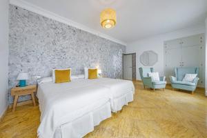 洛斯卡尼奥斯德梅卡Labreña Hotel的一间卧室配有一张白色大床和两张蓝色椅子