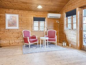 灵克宾8 person holiday home in Ringk bing的木墙客房的两张椅子和一张桌子