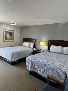 Storm Lake经济汽车旅馆的酒店客房,设有两张床和一盏灯