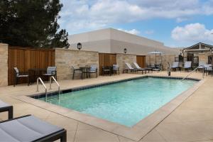 阿比林TownePlace Suites by Marriott Abilene Southwest的庭院内一个带桌椅的游泳池