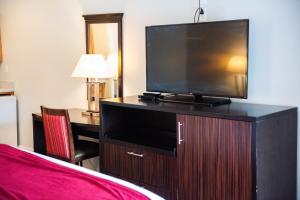SalemCottonwood Inn的酒店客房的梳妆台上配有平面电视