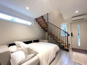 斯德哥尔摩Elegant house Stockholm的卧室配有白色的床和楼梯。