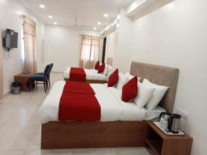 新德里Hotel Fortune Residency的一间卧室配有两张红色和白色床单