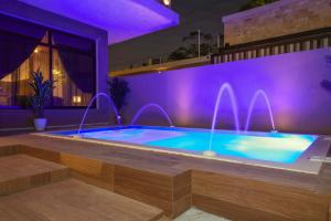 利雅德فلل كاسا الفندقية的紫色照明的房子里的一个游泳池