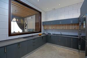 利雅德فلل كاسا الفندقية的厨房配有蓝色橱柜、水槽和窗户。