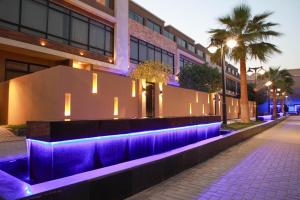 利雅德فلل كاسا الفندقية的街道前有紫色照明的建筑
