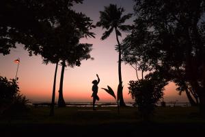 库玛拉孔Coconut Lagoon Kumarakom- CGH Earth的日落时分,一个女人跳下棕榈树