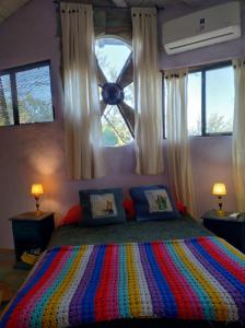 圣哈维尔CasaIsolina的一间卧室配有一张色彩缤纷的床和窗户