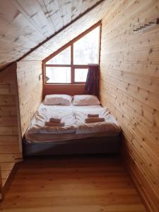 努尔黑姆松Kvamskogen & Hardanger Holliday homes的木制客房的一张床位,设有窗户