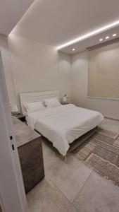 阿哈达فلل شدا ورقان بالهدا的白色的卧室设有一张大床和一个窗户