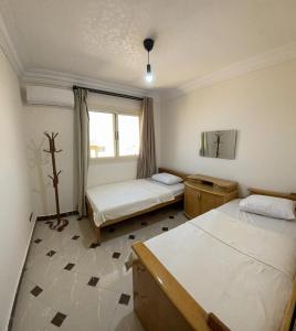 开罗2BD Apartment in a rooftop with a private terrace的客房设有两张床和窗户。