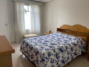 库里提巴Casa do Jardim的一间卧室配有一张带蓝白色毯子的床