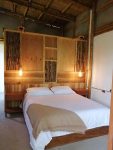 Majestic Coffee Hotel and Restaurant Tierradentro的一间卧室配有一张带木墙的大床