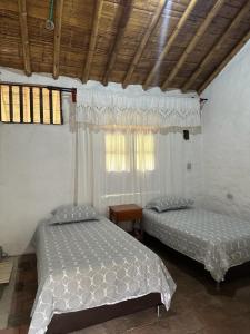 Majestic Coffee Hotel and Restaurant Tierradentro的一间卧室设有两张床和窗户。
