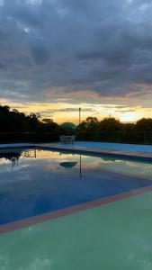 埃尔科莱希奥Hotel Campestre Las Marias- El Colegio的一个空的游泳池,背景是日落
