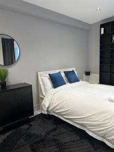 伦敦Stylish entire 2bed apartment的卧室配有带蓝色枕头的大型白色床