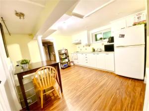 多伦多Cozy Home near Eglinton west Station Toronto!的厨房配有木桌和白色冰箱。
