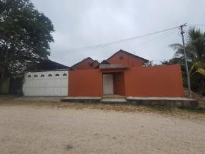 弗洛勒斯Habitacion cerca del lago的一座橙色的房子,设有白色车库