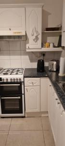 曼彻斯特Scotland Street, Newton Heath的厨房配有白色橱柜和炉灶烤箱。