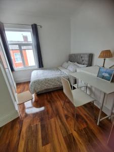 曼彻斯特Scotland Street, Newton Heath的一间卧室配有一张床、一张桌子和一张桌子