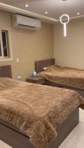 Al Ma‘şarahشقة فندقية فاخرة的卧室内的两张床,配有空调